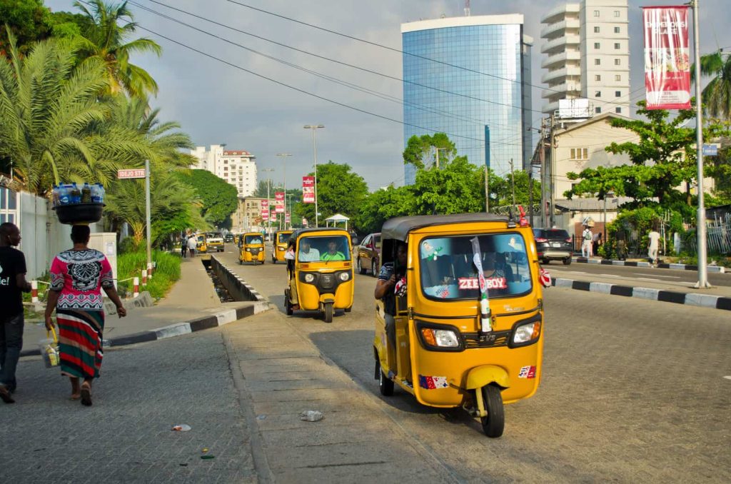 drivers of yellow tuk tuks ply their trade around the port city